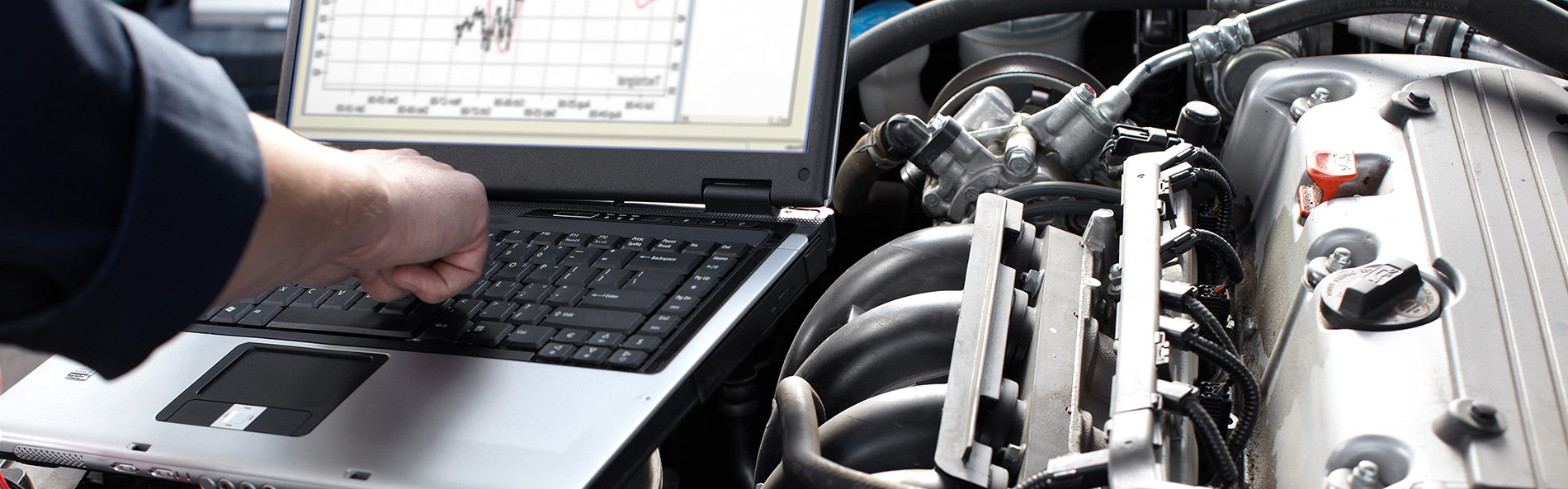 Mechanic using diagnostic equipment on a vehicle